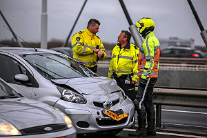 Police officers from the Road Traffic Accident Analysis Department (VOA) and a Rijkswaterstaat roads inspector at an accident on the Van Brienenoord Bridge (photograph: AS Media)