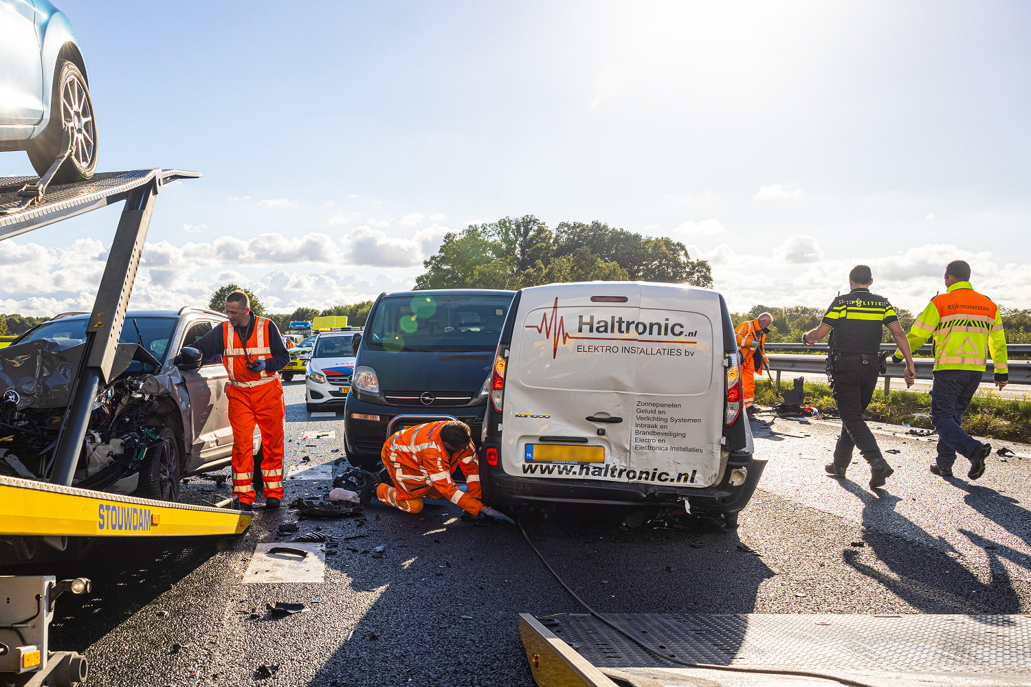 Marcel Bosch (L) and Dirk Wolf of Kraan- en Bergingsbedrijf Stouwdam in a big clean-up on the A28 at Wezep on 6 October 2021. The accident was reported by EDO