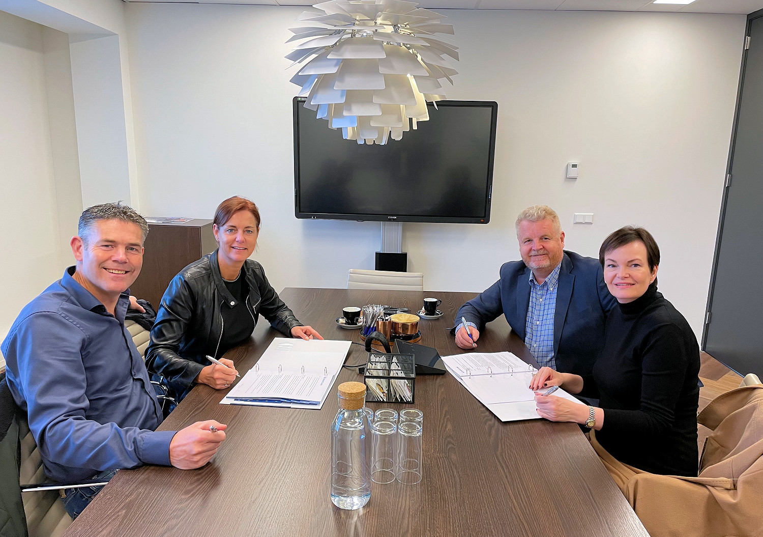 Sander en Nicole Vlaar van Bergnet (beide links) bezegelen met Ron en Sandra Otte de overname van Smits Kraan- en Sleepbedrijf